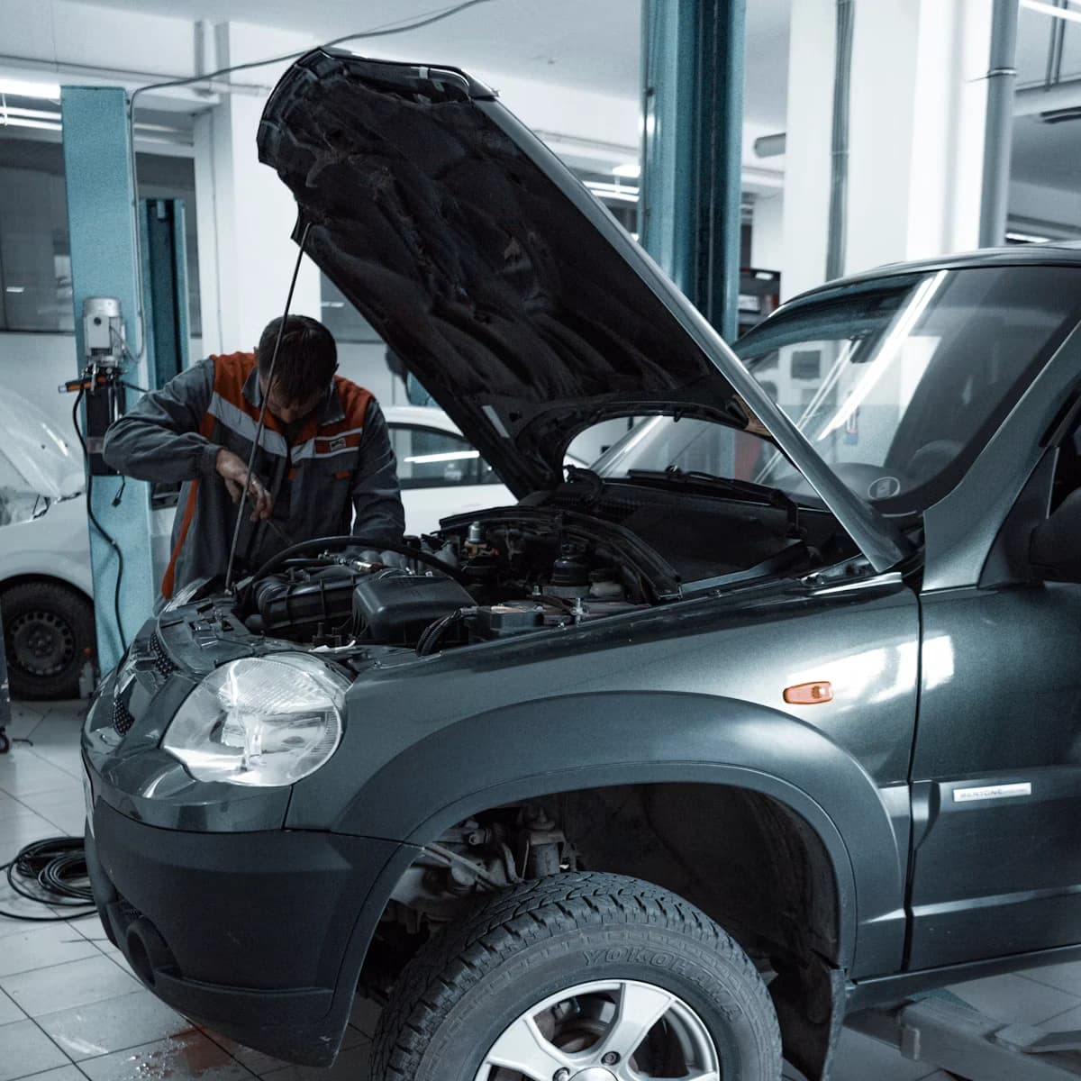 Mechanic completing a car service checklist on a job card in an Indian workshop